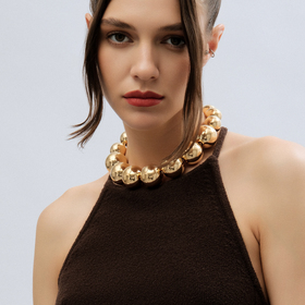 золотистое колье из больших бусин
