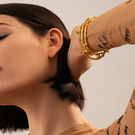 золотистый незамкнутый браслет с узлами